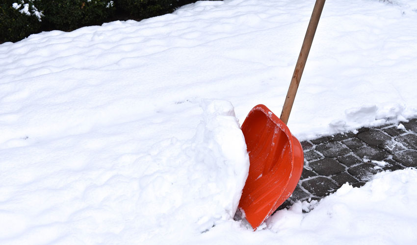 A snow shovel removes snow from a walkway in Northeast Ohio